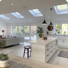 an open kitchen and living room with skylights