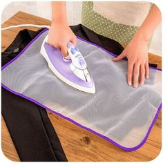 a woman ironing fabric on top of a wooden floor with an electric iron in it