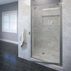 a bathroom with a walk in shower next to a window