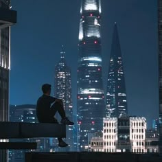 a man sitting on top of a bench in front of a cityscape at night