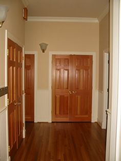 an empty room with wooden doors and hard wood floors