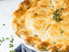 a close up of a pie on a plate with parsley sprigs around it