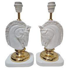 a pair of white and gold horse head lamps