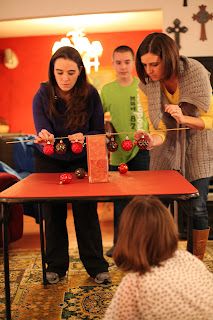 three people standing around a table with candy in front of them and two children sitting on the floor