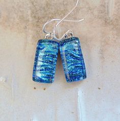 "The stones in these beautiful earrings measure approximately 3/4\" by 3/8\".  They are hung with sterling silver French wire hooks and hang approximately 1 1/4\".  The dichroic glass in these earrings shimmer with blue on black glass.  They are capped with clear and full fused for strength and depth. Thank you for looking in my shop.  All of my pendants and earrings will arrive in a gift box.  I do my best to accurately photograph my work so you will be happy with your purchase. Dichroic Glass changes colors with different lighting and different angles, therefore making it difficult to photograph. You must see my dichroic pieces in hand to appreciate the color and depth of each piece. They are so much more beautiful in person, than in the photographsyou must see to appreciate.   Thanks, a Sterling Silver Blue French Hook Earrings, Blue Sterling Silver Earrings With French Hook, Gift Dangle Linear Earrings With Lever Back, Gift Linear Dangle Earrings With Lever Back, Silver Linear Earrings With French Hook Gift, Blue Nickel-free Linear Earrings For Gift, Long Drop French Hook Earrings For Gift, Sterling Silver Drop Earrings With Lever Back, Sterling Silver Drop Linear Earrings With Lever Back