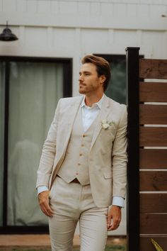 a man in a suit standing next to a building