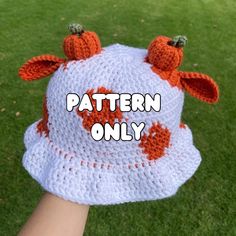 a crocheted cow hat with the words pattern only written on it in white and orange