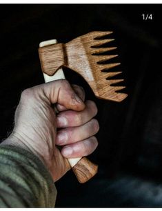 a person holding two wooden spatulas in their hands, one is made out of wood