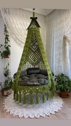 a green hanging chair with pillows on it