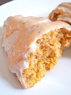 two glazed donuts on a white plate with icing