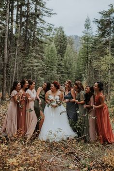 a group of women standing next to each other in the woods