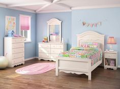 a child's bedroom with blue walls and white furniture, including a pink rug