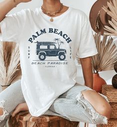 Palm Beach Shirt | Palm Beach Crewneck | Palm Beach Florida | Vintage Florida Shirt | Florida Gifts | Palm Beach Tshirt | Jeep Shirt Women ▹ SIZING AND ITEM DETAILS * T-Shirt sizes are UNISEX. Please check photos for detailed measurements. Try comparing the measurements to your favorite t-shirt that fits just the way you like it! * Main photo shows the White t-shirt. Design can also be printed on Athletic Heather. Clicking on each color in the dropdown box will show that color's photo. Design is printed in Navy for all shirt colors. * White is 100% combed and ring-spun cotton * Athletic Heather is 90% combed and ring-spun cotton, 10% polyester * Fabric weight: 4.2 oz (142 g/m2) * Pre-shrunk fabric * Side-seamed construction * Design is printed using direct-to-garment (DTG) print on Bella C White Tropical T-shirt For Beach Season, Casual Crew Neck T-shirt For Vacation, Trendy White Print T-shirt For Beach, White Text Print Tops For Beach, Trendy White Print T-shirt For Vacation, Casual White T-shirt For Vacation, Casual Crew Neck Top With Palm Tree Print, White Text Print Top For Vacation, Tropical T-shirt For Beach Vacation