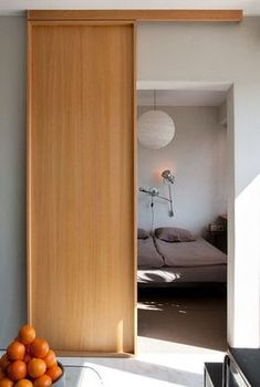 an open door leading to a bedroom with a bed and fruit on the table in front of it