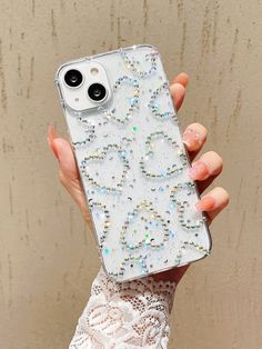 a woman is holding up her phone case with beads on the front and back cover