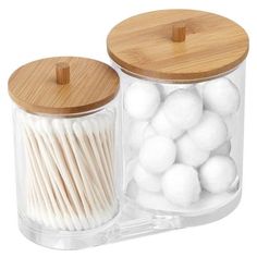 two clear jars with wooden lids and white cotton balls in the bottom one has a bamboo lid