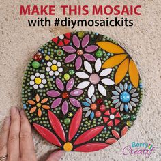 a hand is holding a colorful mosaic on the ground with text overlay that reads make your own mosaic with diymosaicies