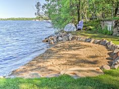 a chair sitting on top of a sandy beach next to the water's edge