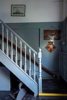 stairs leading up to the second floor in an old building with pictures on the wall