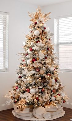 a white christmas tree with gold and red ornaments