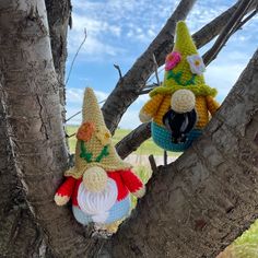 two crocheted gnomes are sitting in a tree