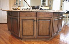 a kitchen island with granite top and wooden cabinets