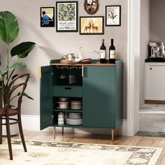 a green cabinet sitting in the corner of a room next to a table with plates and cups on it