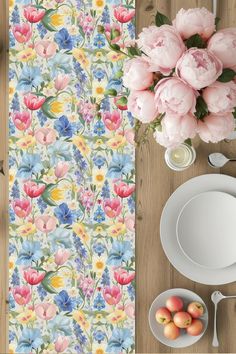 a table topped with plates and flowers next to a vase filled with pink peonies