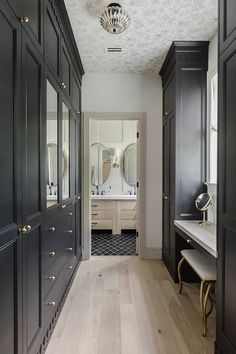 a long hallway with black cabinets and mirrors