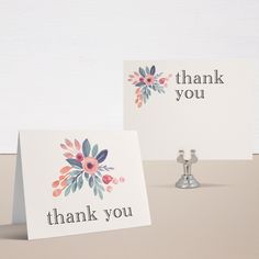 two thank you cards sitting on top of a table