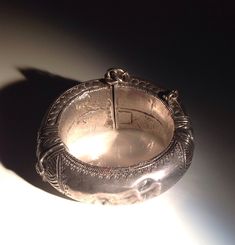 "Spectacular acanthus repousse with geometric borders. Weight is about 96 grams. A handsome example of the craftsmanship of the Indian silversmith during the time of the Raj. Condition is excellent with the heavy patina, wear, and minor dents that I like to see in an antique tribal piece. This bracelet has a small key which is inserted into an open hinge and turned to secure it. The open hinge has an iron pin (probably for strength). Dimensions: 6.75\" in circumference. No bigger wrist will fit. Traditional Sterling Silver Bracelet For Formal Occasions, Traditional Handmade Sterling Silver Bracelet For Formal Occasions, Traditional Engraved Sterling Silver Bracelet For Formal Occasions, Traditional Engraved Bracelets, Traditional Engraved Collectible Bracelets, Traditional Oxidized Bracelets For Formal Occasions, Traditional Round Sterling Silver Bracelet For Ceremonial Use, Ceremonial Traditional Sterling Silver Bracelet, Traditional Ceremonial Sterling Silver Bracelet