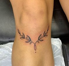 a woman's lower leg with a tattoo on her left side and an arrow in the middle