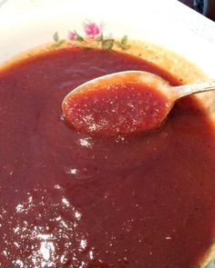 a spoon in a bowl filled with sauce