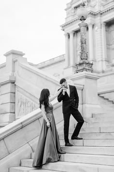 a man and woman standing on some stairs