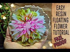 a person holding a flower in their hand with the words easy resinin floating flower tutorial