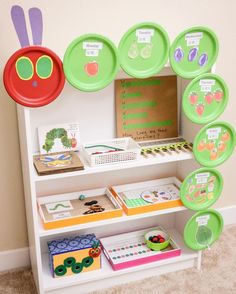 there are many plates and cards on the shelves in this playroom that is filled with paper plates