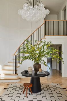 a room with a table, chairs and a chandelier hanging from the ceiling