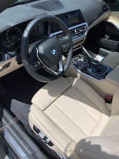 the interior of a car with beige leather seats and steering wheel, dash board and center console