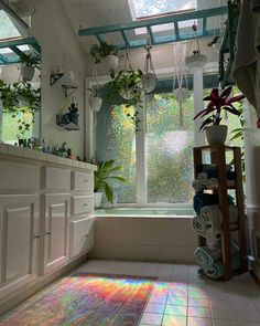 the sun shines through the windows in this bathroom with white tile flooring and potted plants