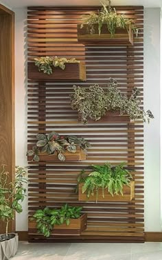 a wall mounted planter filled with lots of plants next to a wooden slatted wall