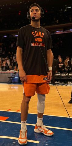 a man standing on top of a basketball court wearing orange shorts and headphones with the words 3 points for facebook