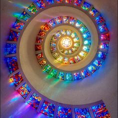 a spiral stained glass window in the center of a room with many windows on it