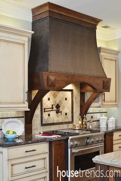 a stove top oven sitting inside of a kitchen next to wooden cabinets and counter tops