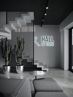 a black and white photo of a living room with cactus in the corner next to stairs