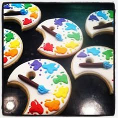 decorated cookies with paint and brush on them are ready to be eaten by the child