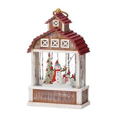 a christmas scene with a snowman and tree in front of a small wooden house