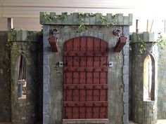 a model of a castle with a red door and green ivy growing on the walls