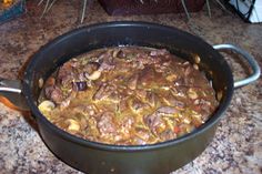 a pot filled with stew sitting on top of a counter