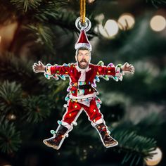 a christmas ornament hanging from a tree with a man dressed as santa clause