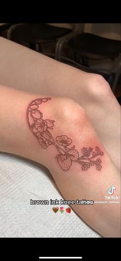 a woman's leg with a tattoo on it that has flowers growing out of it